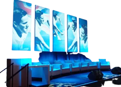 Delegates seated in front of a curved LED screen during a corporate plenary session.