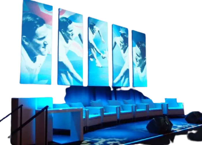 Delegates seated in front of a curved LED screen during a corporate plenary session.